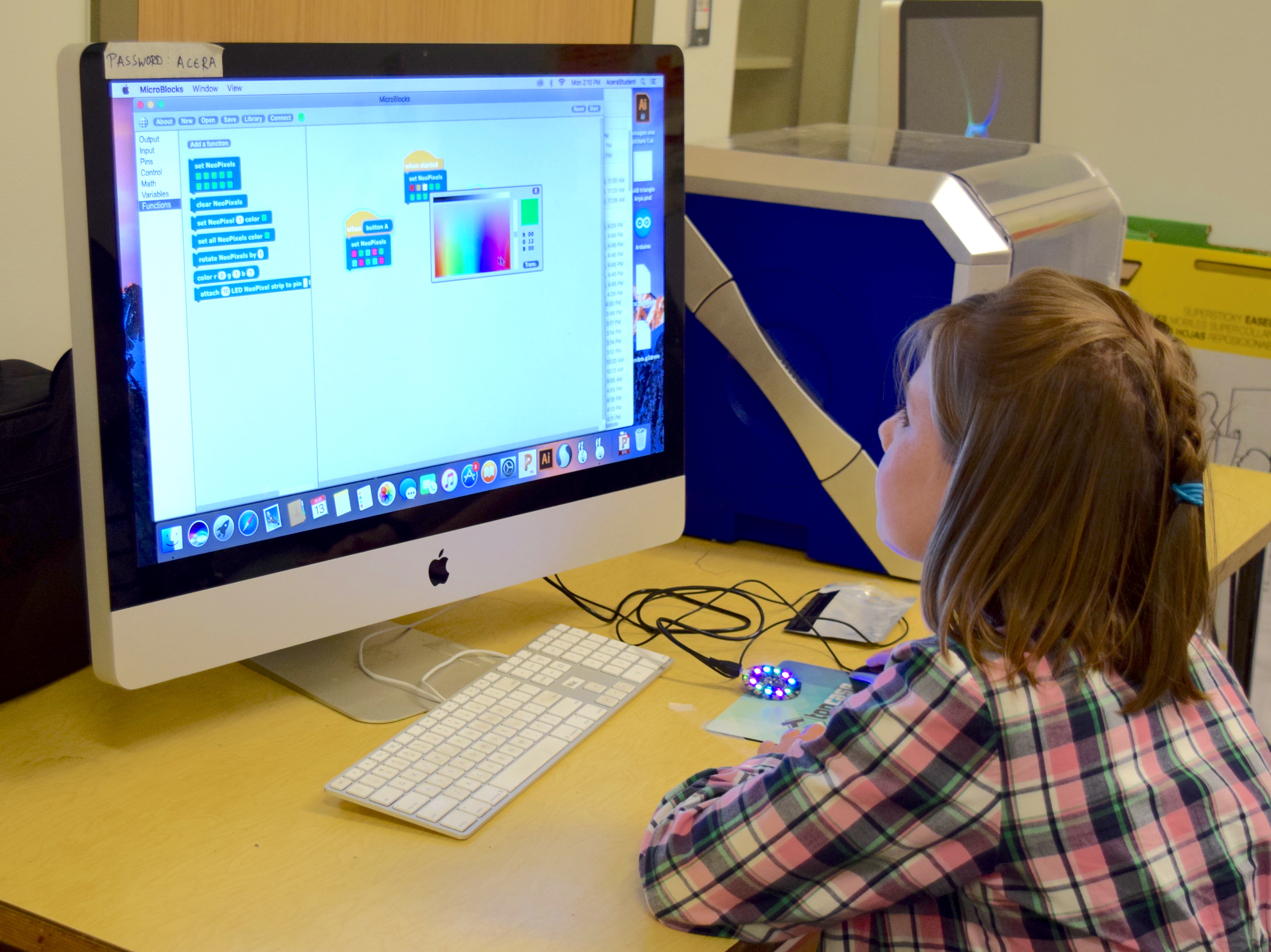 picture of young girl at a computer, programming with MicroBlocks