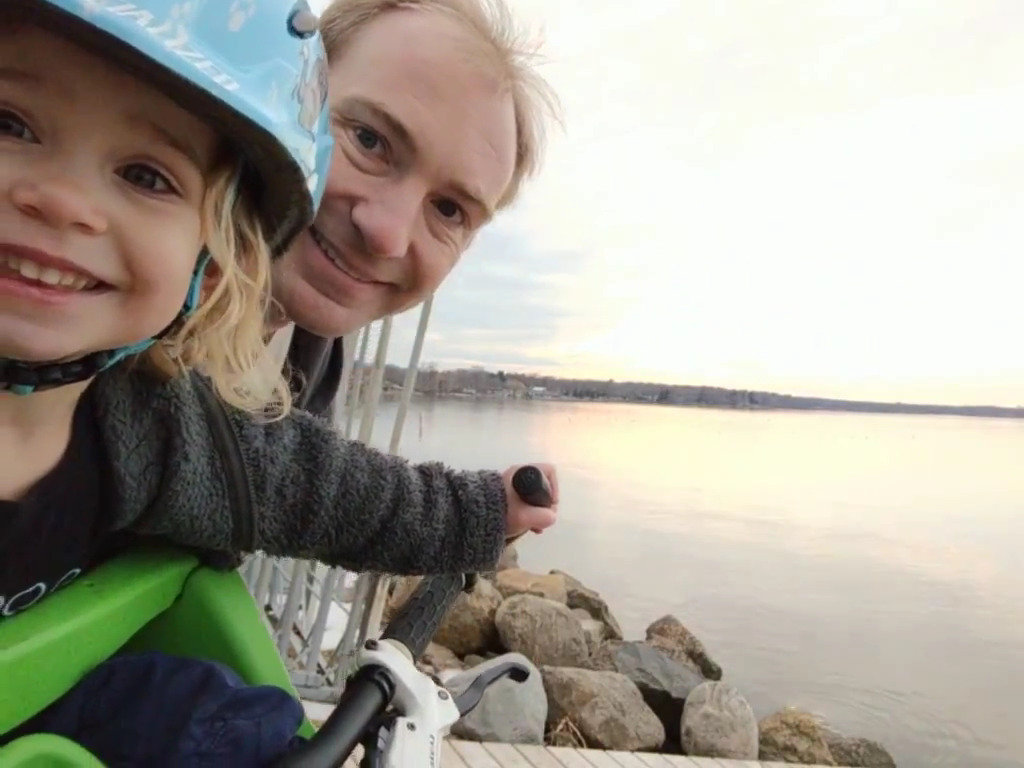 Sage helping his daughter ride a bike.