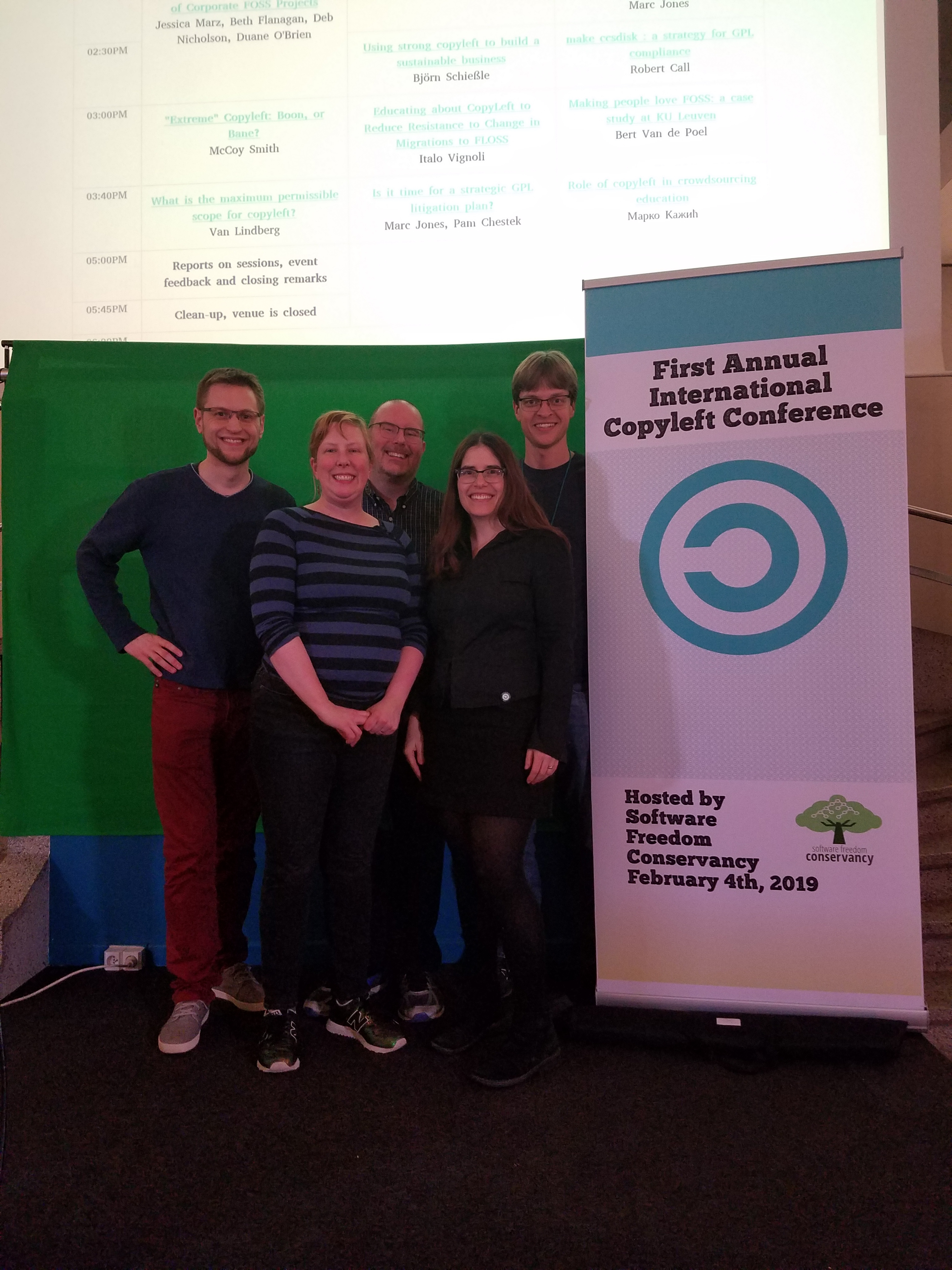 Conservancy staff members in front of a Copyleft Conf sign.