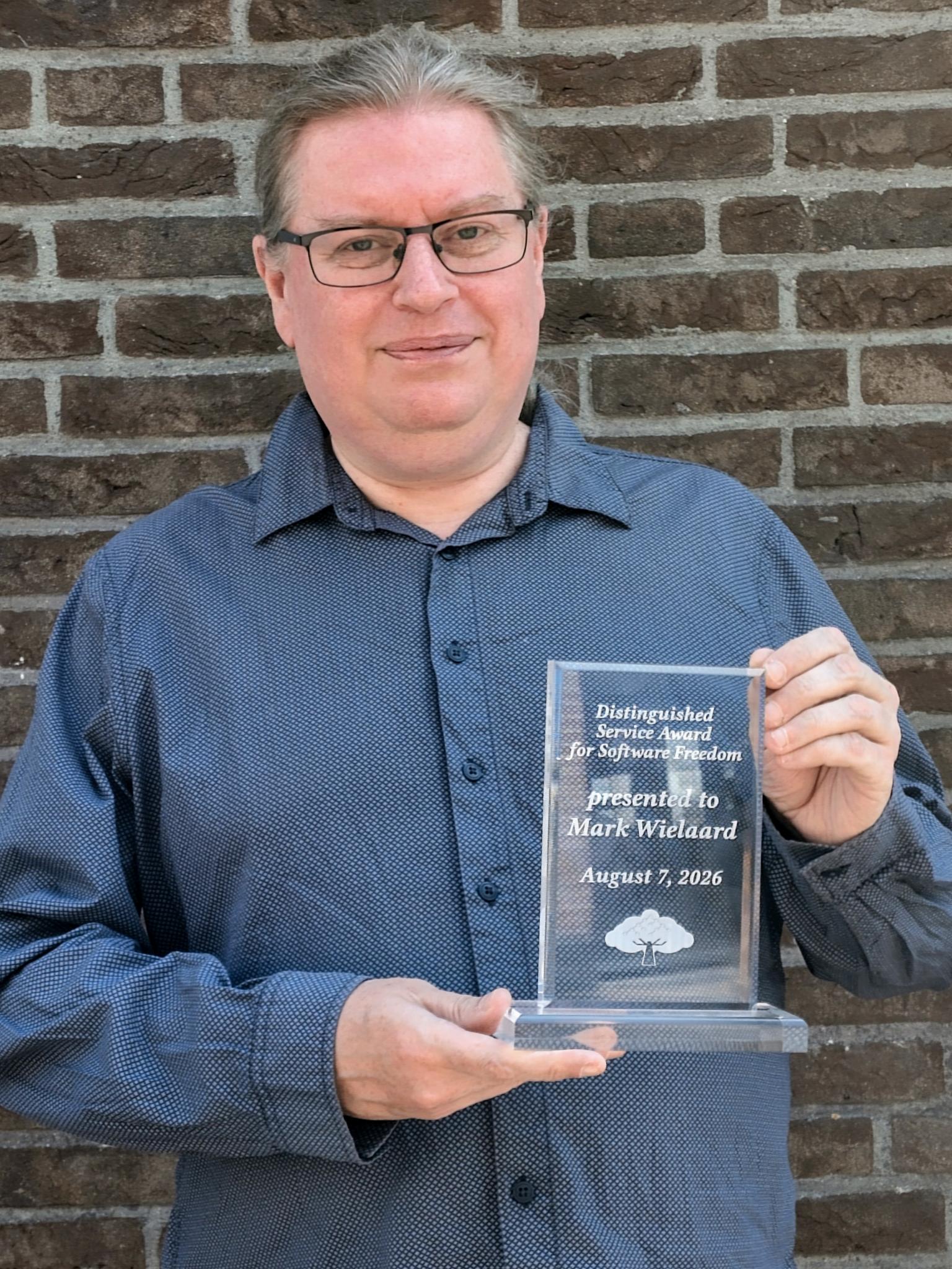 Photo of Mark J. Wielaard holding award